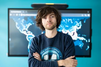Boyan Slat, Founder & CEO, standing in front of The Ocean Cleanup's 1000 rivers pollution map