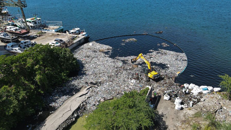 Trash being offloaded from the Interceptor Barrier in Tivoli Gully, Kingston Harbour, Jamaica