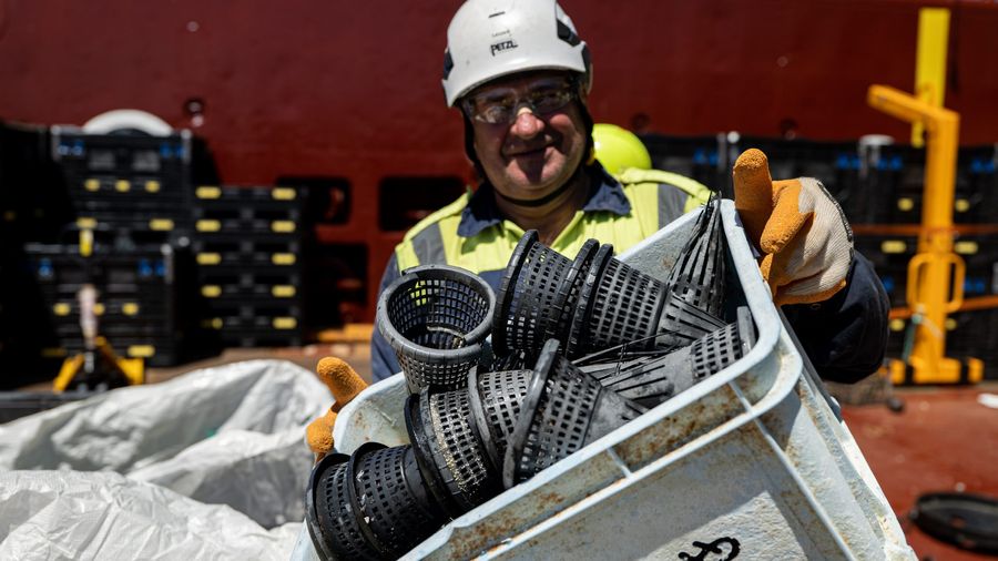 Crew on board the support vessels of System 002, holding up a crate with eel traps. Eel traps is an item we find in large quantities, as are crates.